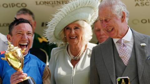 Frankie Dettori celebrates with the trophy, alongside King Charles III and Queen Camilla after his victory on Courage Mon Ami in the Gold Cup