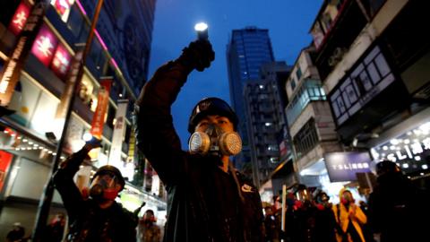 Demonstrators protesting the proposed extradition bill aim their flashlights towards riot police as they are chased through the streets of Hong Kong, China, August 25, 2019