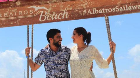 The couple posing by a sign in Mexico