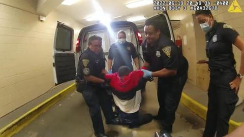 Two officers are seen dragging Randy Cox out of the van by his arms from a still of police body camera video.