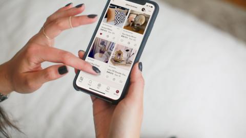 A hand opens Poshmark app