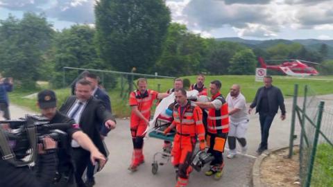 Robert Fico being wheeled into hospital on a stretcher