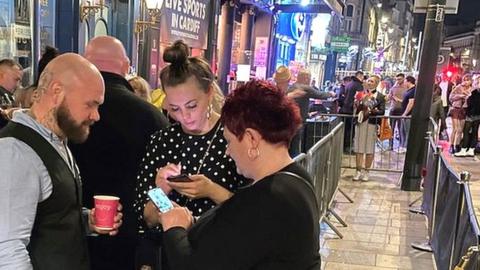 A doorman checking covid passes