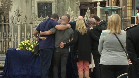 Family members of three men stabbed to death in a park in Reading have lit candles at a vigil.