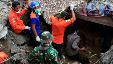 Indonesian army and the Search and Rescue Team look for survivors amongst the rubble on 7 December 2016 in Lueng Putu town, Aceh Province, Indonesia.