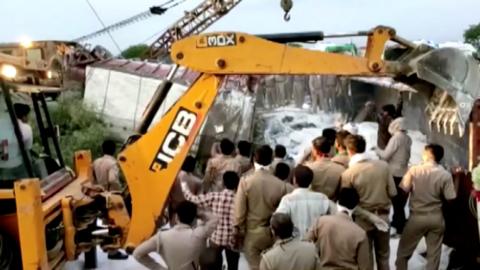 Rescue workers attend the scene of a collision between two lorries in the Auraiya district of Uttar Pradesh (16 May 2020)