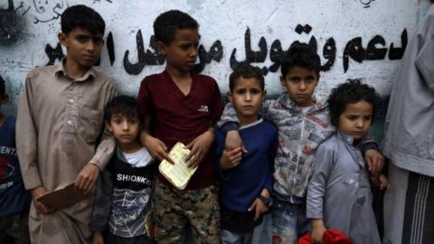 Children queue for aid in Sanaa, Yemen