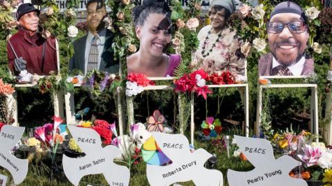 Street memorials of flowers and candles and messages surround the Tops supermarket where a racist gunman murdered ten African Americans with an assault rifle, June 18, 2022 in Buffalo, New York.