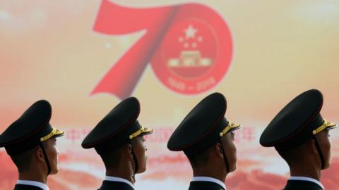 Soldiers of People"s Liberation Army (PLA) are seen in front of a sign marking the 70th founding anniversary of People"s Republic of China before a military parade on its National Day in Beijing, China October 1, 2019.