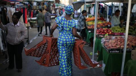 A trader carries trays at East Street Market in south London on September 2, 2017
