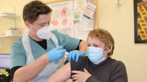 GP Eilir Hughes injecting a patient