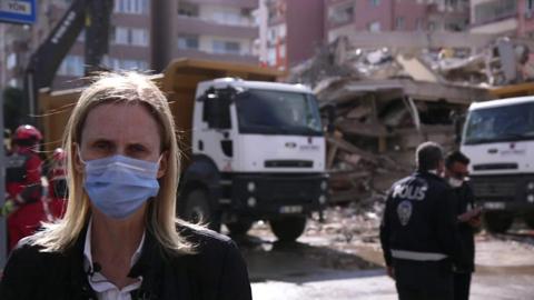 Orla Guerin stands in front of destroyed building