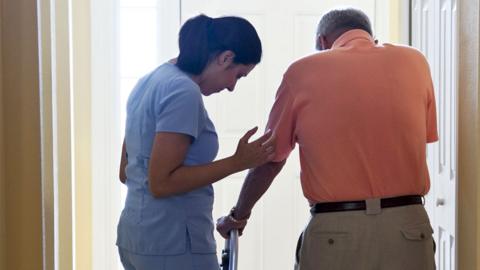 Stock image of a carer supporting a patient