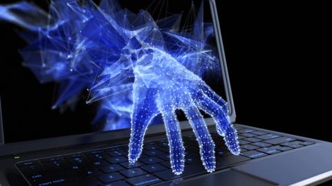 Digital hand emerging through computer screen