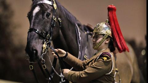 Members of the Household Cavalry Mounted Regiment prepare for a night time rehearsal for the coronation of King Charles III at Hyde Park Barracks on 17 April 2023 in London, England