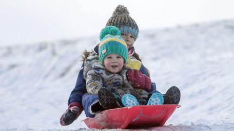 Children are seen sledging on a snow covered golf course on November 27, 2021 in Carrbidge, United Kingdom. The Met Office has issued the highest level of warning as wind speeds between 80 and 90mph hit north east Scotland and north east England bringing snow.