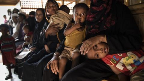 Children sit on laps in Cox's bazaar camp