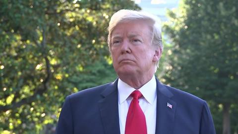 Donald Trump is photographed gazing into the middle distance in a sunny outdoor scenario