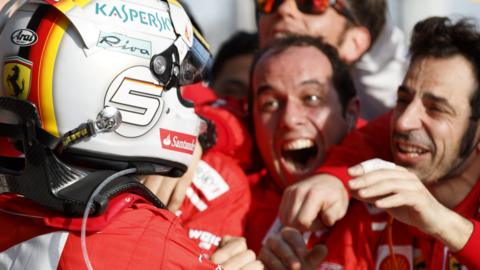 Ferrari driver Sebastian Vettel is mobbed by his team after winning the Australian Grand Prix