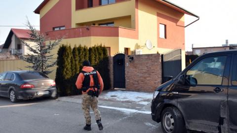 A Slovak policeman walks outside a house linked to Italian businessman Antonin Vadala during a police search