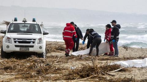 Rescuers recover a body after a suspected migrant boat is wrecked and bodies believed to be of refugees were found in Cutro, the eastern coast of Italy's Calabria region, Italy, on 26 February 2023