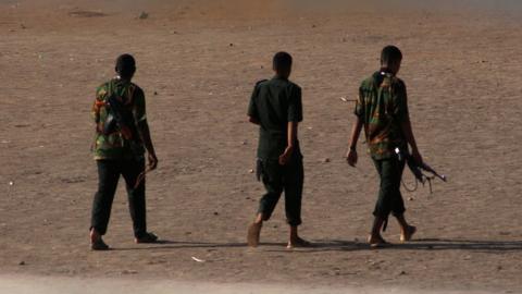Armed men walk in Khartoum on Monday