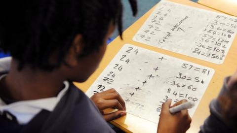 Pupil filling out arithmetic work at school