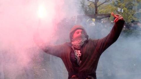 A protester holds a flare at a demonstration in Brussels against the UN migrant compact