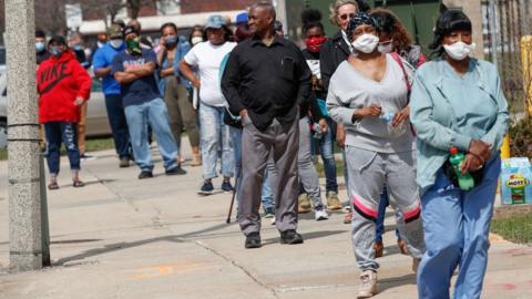 Residents wait in long line to vote in a presidential primary election outside the Riverside High School in Milwaukee, Wisconsin, on April 7, 2020