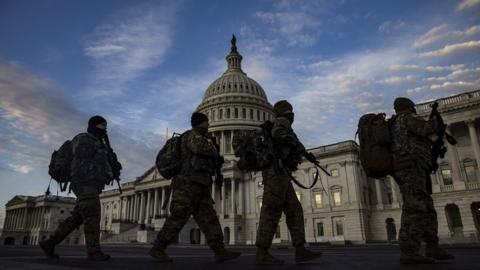 National Guard troops march past the US Capitol building as day breaks in Washington, DC, USA, 14 January 2021