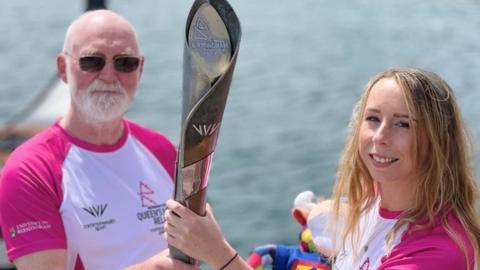 Neil Kegg and Rossana Dale holding the Queen's baton