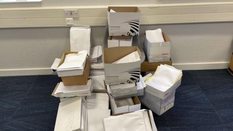 Piles of medical paperwork created by the cyber attack