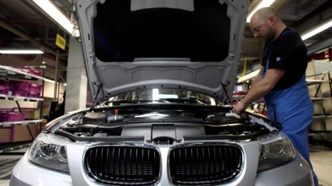 A man checks a car on the BMW 3-series production line at the BMW factory on March 15, 2010 in Munich, Germany.