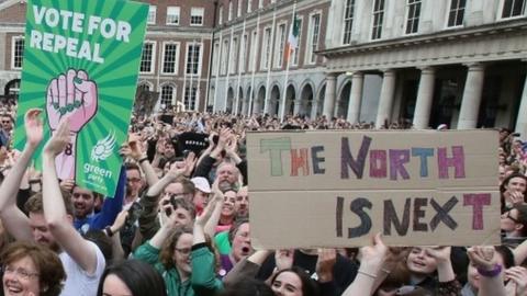 Pro-choice campaigners celebrate the result of the Irish abortion referendum, with some holding a poster saying: "The North Is Next"