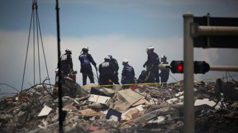 Rescuers search through the rubble of a collapsed apartment block near Miami, Florida, June 2021