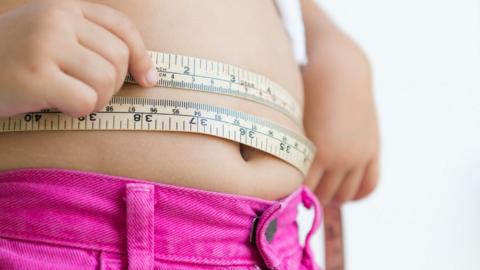 Girl measuring her waist with a tape