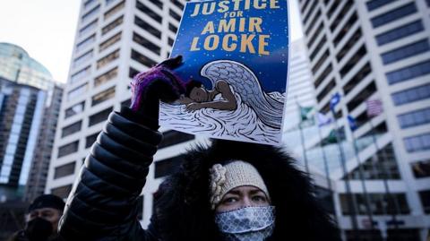 Woman holds sign at Minneapolis protest