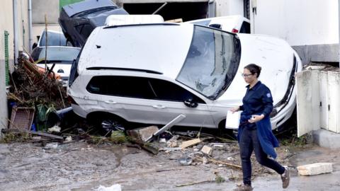 A woman walks past damage in Sant Llorenc on 10 October