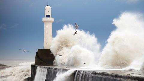 waves crashing around lighthouse
