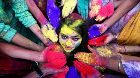 College students pose for a photo as they take part in the Holi festival