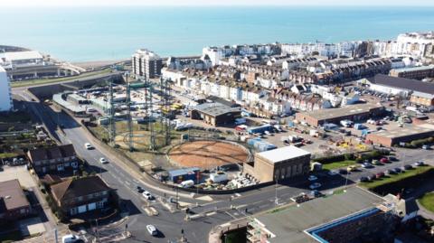 An aerial shot of the Brighton gasworks with houses and the sea in the background