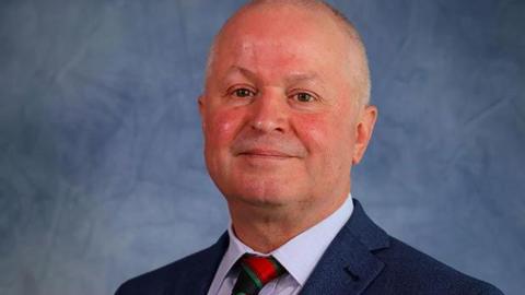 Sean Morgan in a council portrait, with a striped tie, a white shirt and a blue jacket.
