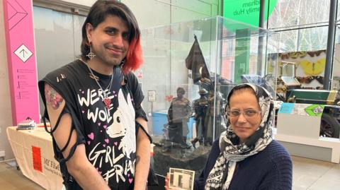 Ibrahim Chisti and his mother Sharon holding a photo of her father, Charlie.