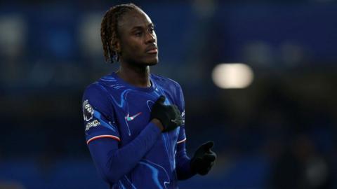 Trevoh Chalobah pats the Chelsea badge on his shirt