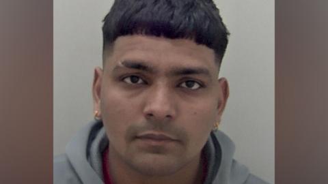 A close-up portrait shows Jaskirat Singh facing the camera against a plain light background, with short dark hair, a grey hooded top and small earrings visible.
