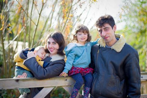 Father and mother with two children, one a toddler and one a baby. 