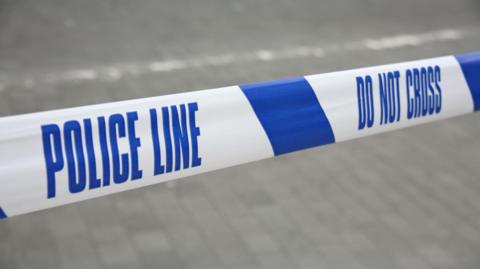 Cordoned off police line by blue and white tape