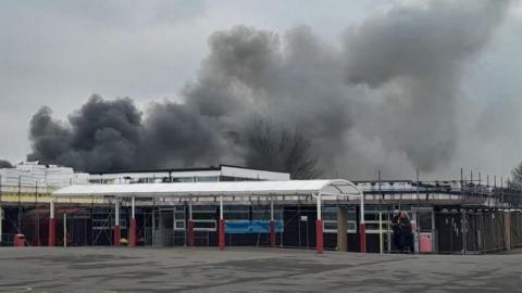 A school on fire. There is smoke in the background