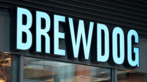 A Brewdog sign above a bar in blue lettering.