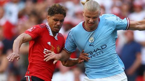 Manchester United's Raphael Varane in action with Manchester City's Erling Haaland